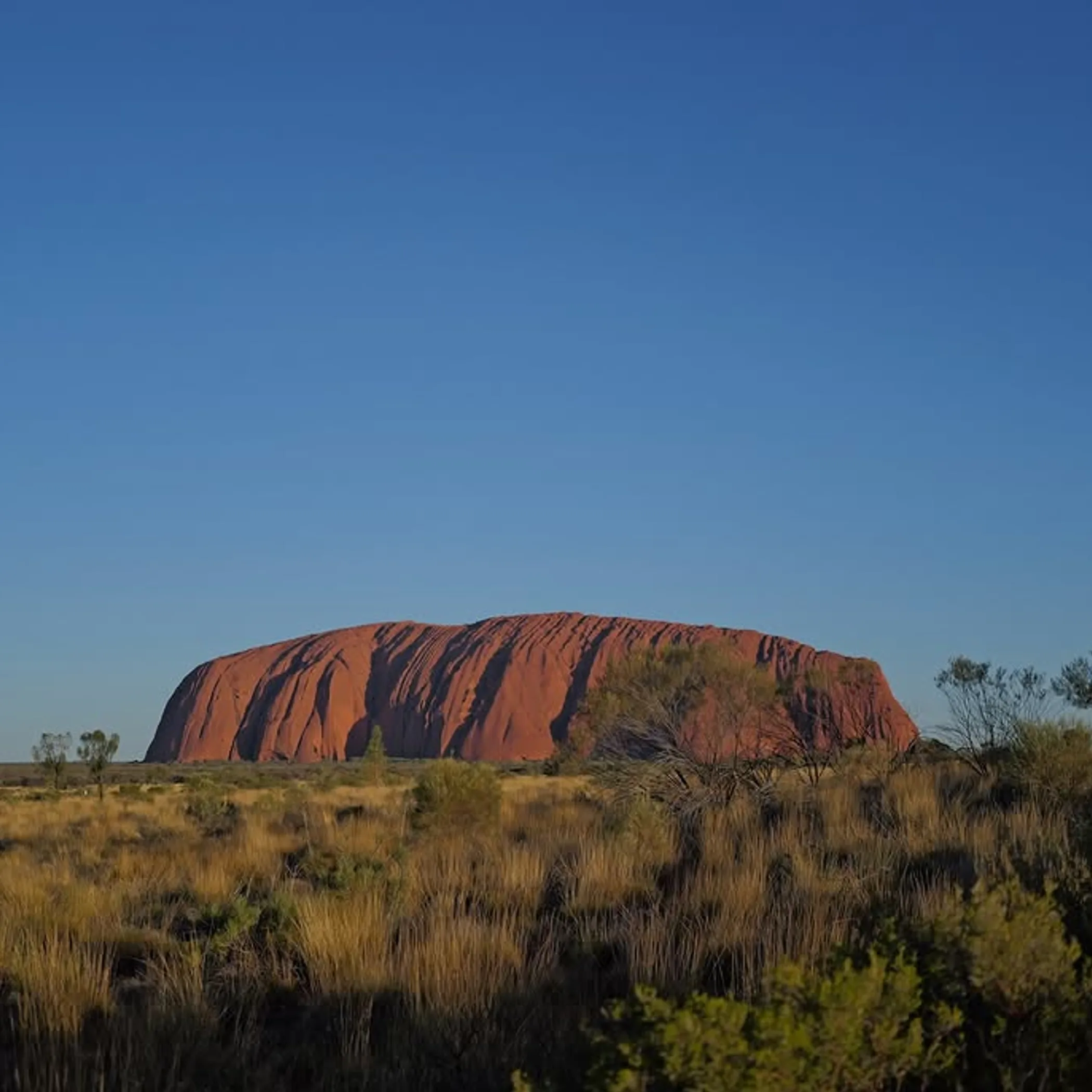 uluru rock formation under clear sky